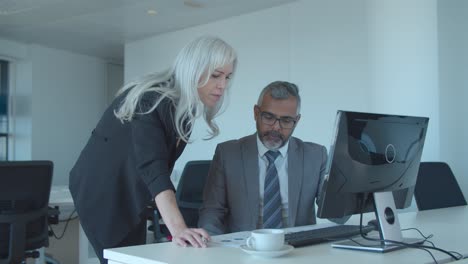 serious male professional explaining reports to female boss