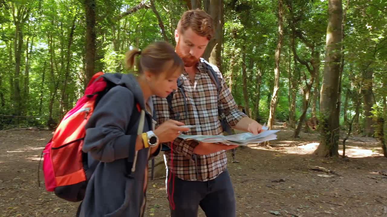 pareja discutiendo el mapa en el campamento de entrenamiento 4k