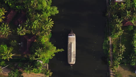 Toma-Aérea-De-4.000-Drones-A-Vista-De-Pájaro-De-Una-Casa-Flotante-Moviéndose-En-Los-Remansos-De-La-Pista-De-Alapuzha