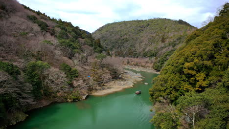 beautiful drone shot of boat on a river in kyoto japan