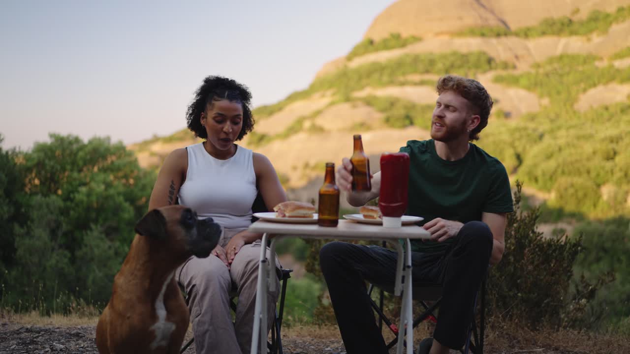 People having a meal outdoors with a dog