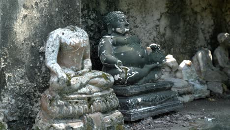 Stone-statues-of-Fat-Buddha-and-headless-Buddhist-figure-in-meditation