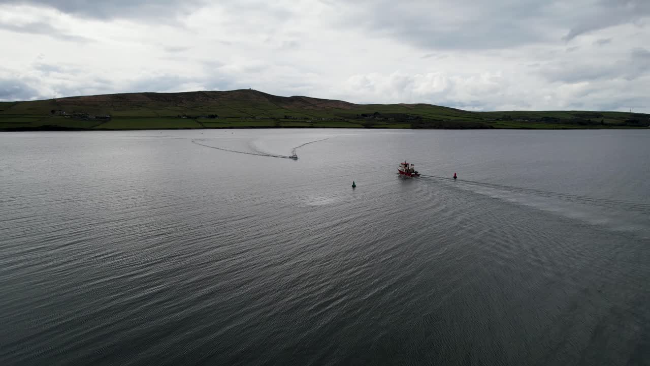 Både krydser, droneoptagelse fra Dingle, Irland, overskyet og roligt hav.