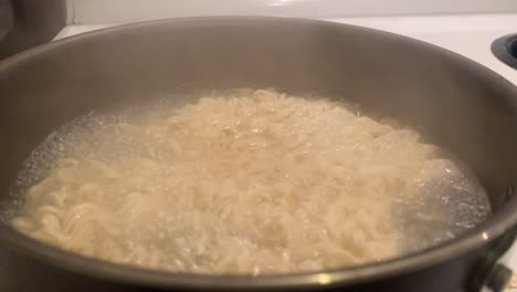 breve clip de fideos hirviendo y el stgeam saliendo de la olla hirviendo