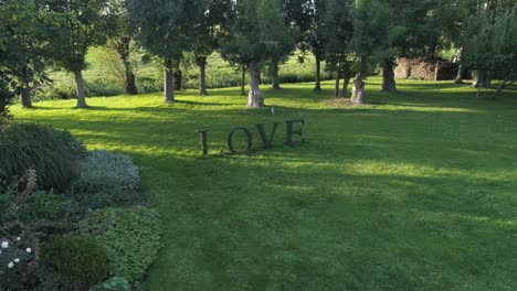 Signo-De-Amor-Hecho-De-Plantas-Destinadas-A-Eventos-Románticos-Durante-La-Puesta-De-Sol-Con-árboles-En-El-Fondo