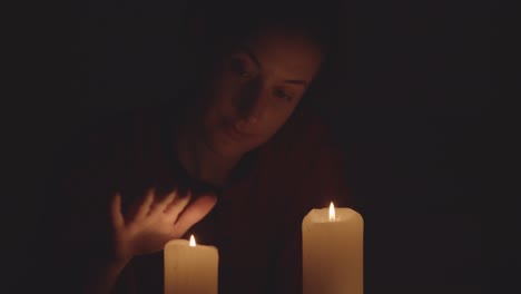 mujer y velas en la oscuridad