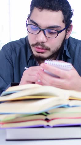 young student writing notes during study session