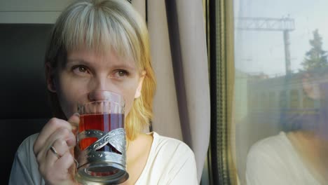 A-Woman-Is-Drinking-Tea-On-The-Train-Traveling-With-Comfort-4k-Video