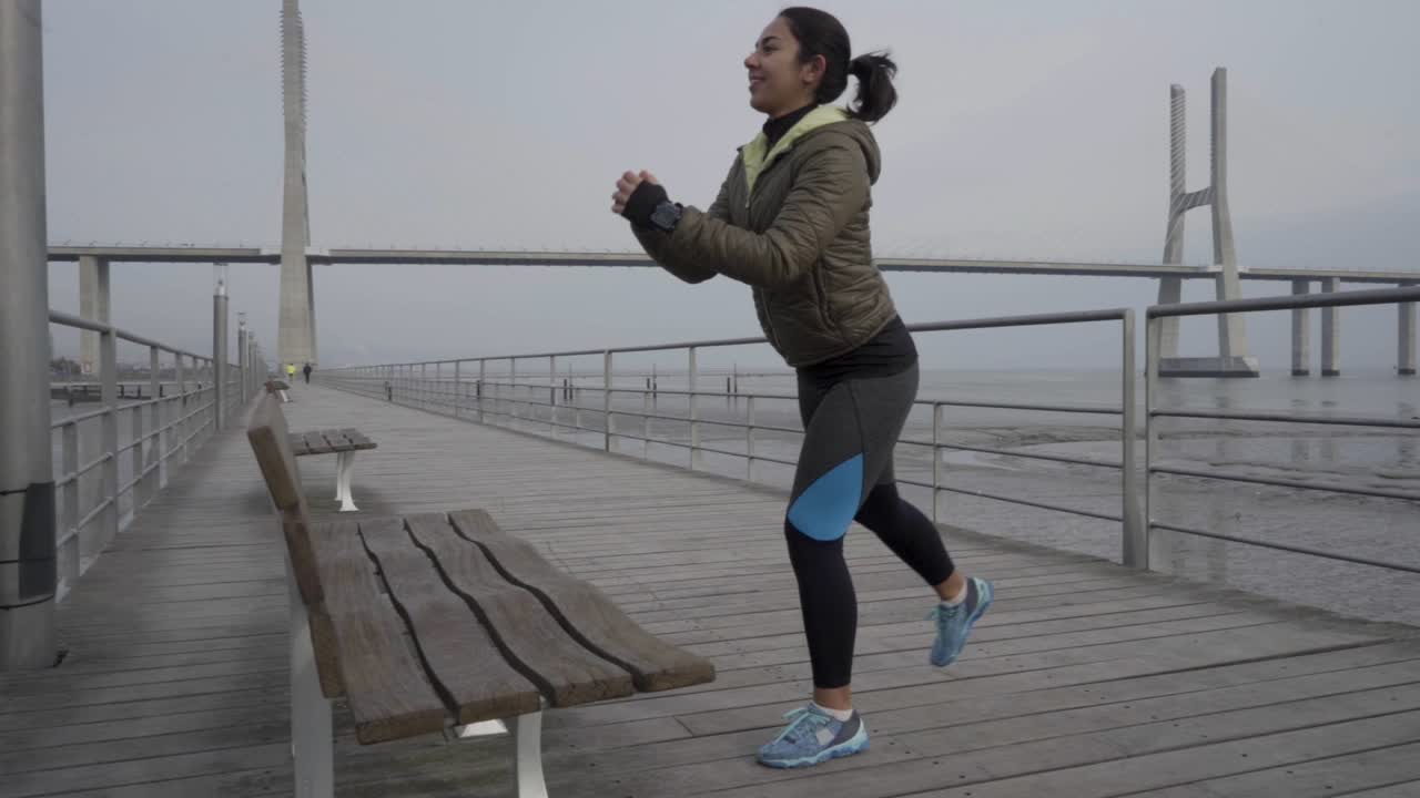 Smiling hindu woman training on wooden pier