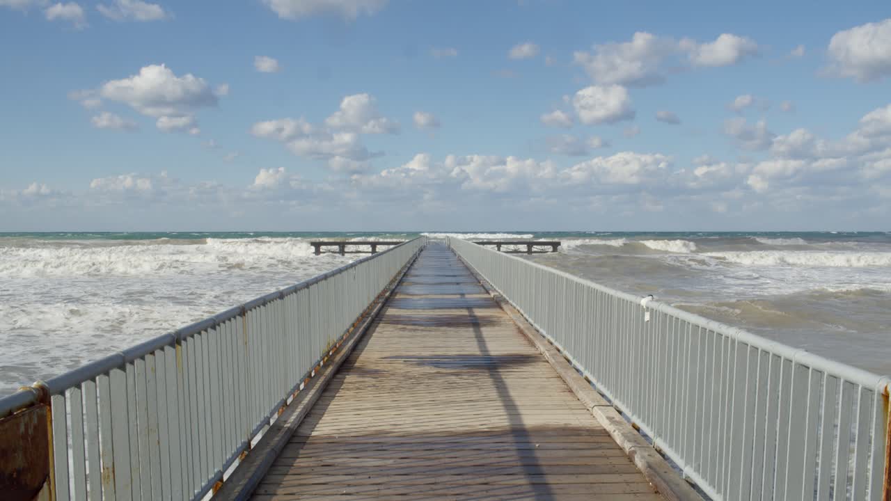 mar mediterráneo salvaje olas de invierno y cielo nublado por el muelle en chipre, cámara lenta