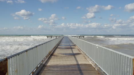 wild mediterranean sea winter waves and cloudy sky by the pier in cyprus, slow motion