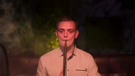 man smoking hookah in a lounge