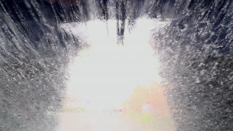 an automatic drive through car wash in operation as seen through the windscreen of a private automobile, worcestershire, england