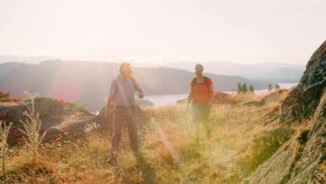 fotografía en cámara lenta de una pareja de ancianos caminando por la cima de una colina en una caminata a través del hermoso campo en el distrito de los lagos del reino unido