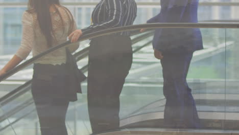 diverse male and female business people using escalator, over cityscape