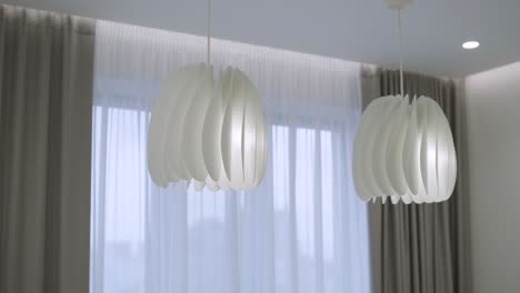 dos lámparas colgantes modernas blancas, candelabros esféricos de tela de estilo escandinavo sobre un fondo gris
