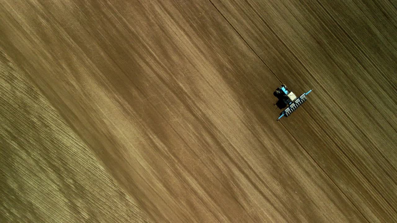 tierra agrícola de primavera. tractor con un cultivador en un campo de primavera. fotografía aérea.