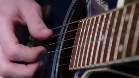 a curly red-haired boy of american appearance is learning to play the guitar. guitarist’s hand close-up. education and hobbies.