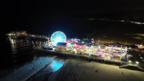 the famous, iconic santa monica pier at nighttime - push in aerial of amusement park