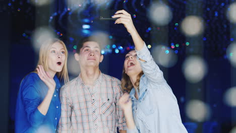 los jóvenes se divierten en una fiesta usan un teléfono inteligente 1