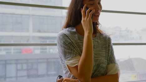 Businesswoman-talking-on-mobile-phone-in-a-modern-office-4k