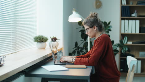 joven mujer de negocios trabajando en una computadora portátil en el escritorio de la oficina