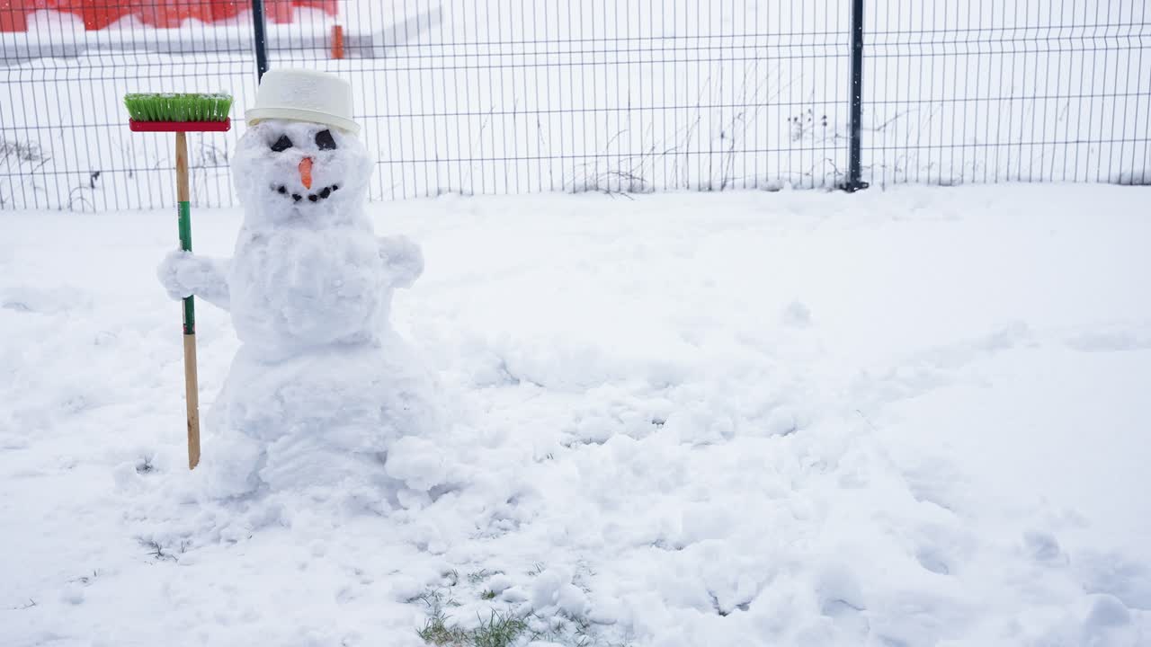 穏やかな雪の庭に、ほうきを持ったかわいらしい雪だるまが誇らしげに立っています。柔らかな雪と白い景色が魔法のような冬の風景を作り出し、子供の頃の不思議な感覚を呼び起こします。