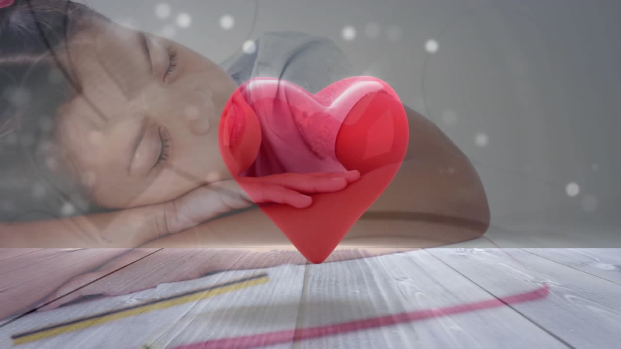 Girl resting on wood table heart appearing above folded arms rotating particles drifting for health