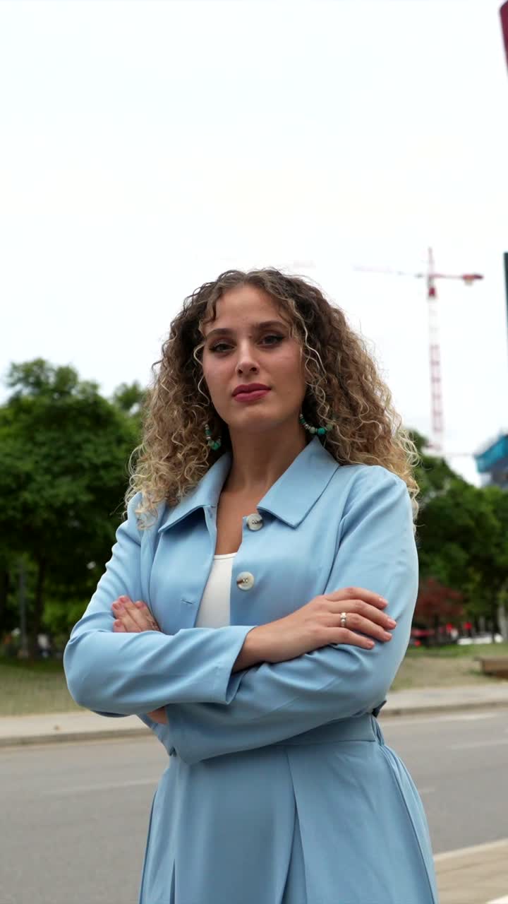 Retrato de uma mulher de cabelos cacheados com uma jaqueta azul