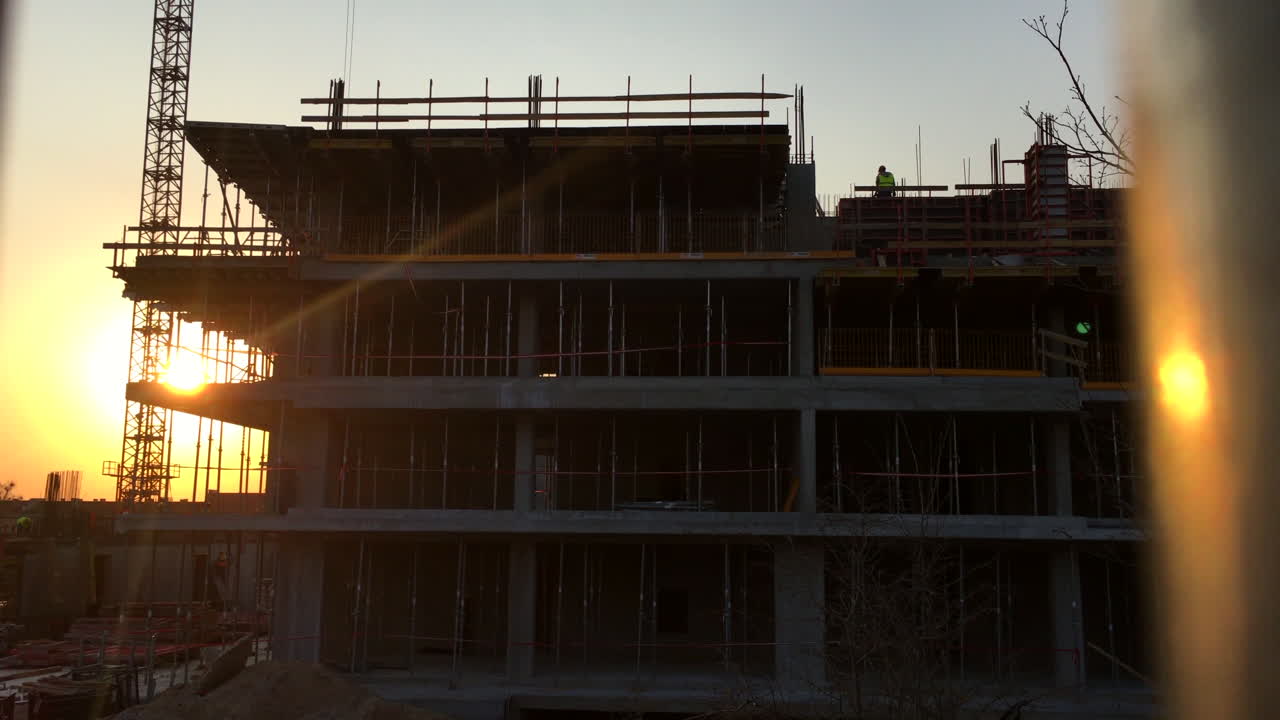 grúas de construcción y construcción de bloques al atardecer