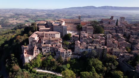 Vista-Aérea-De-La-Ciudad-Medieval-Todi-En-La-Cima-De-Una-Colina-Verde,-Umbría,-Italia