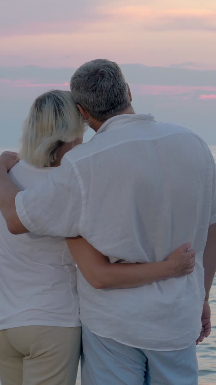 Coppia di anziani che si gode un tramonto sulla spiaggia