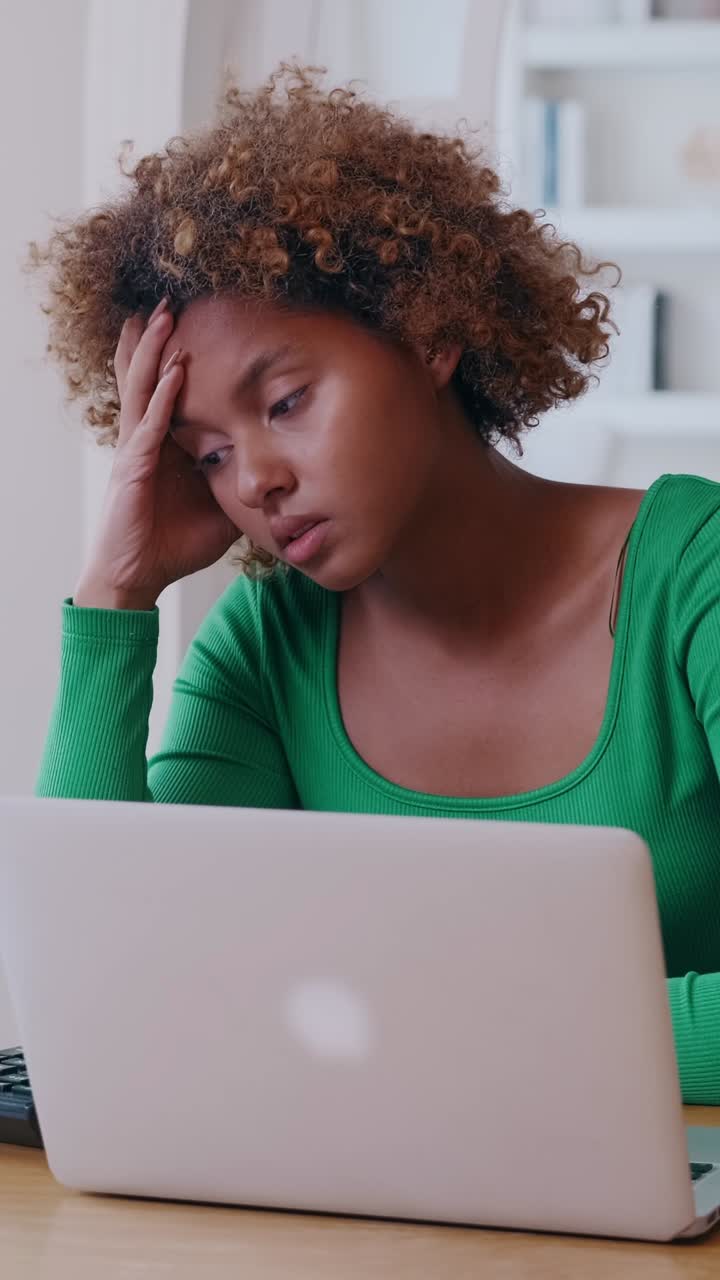 Young mixed race woman focused on laptop in home remote work or online study