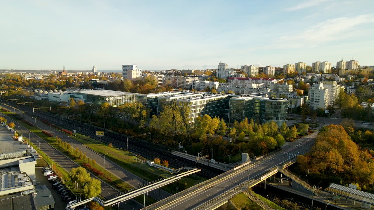 Silta valtatien ja rautatien yli lähellä Redłowon rautatieasemaa ja PPNT-rakennusta Gdyniassa, Puolassa auringonnousun aikaan.