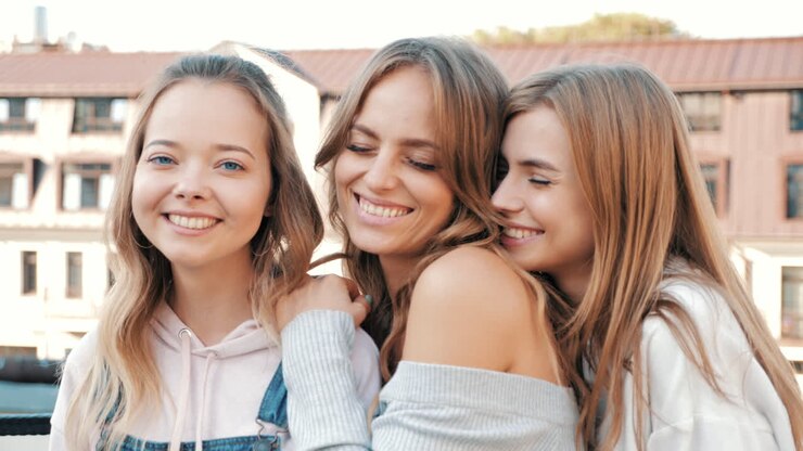 Três amigas felizes posando ao ar livre