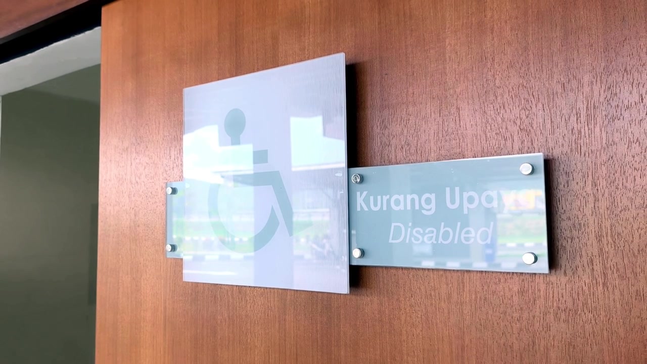 Značka bezbariérového WC je bezpečně připevněna na zdi. Poskytuje jasnou viditelnost pro každého. Symbol invalidního vozíku označuje inkluzivní veřejné zařízení.