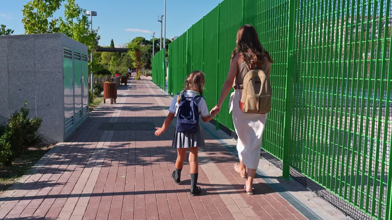 Eine Mutter und eine Tochter, die die Straße entlanggehen
