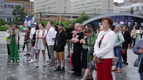 people watching an event in a city plaza