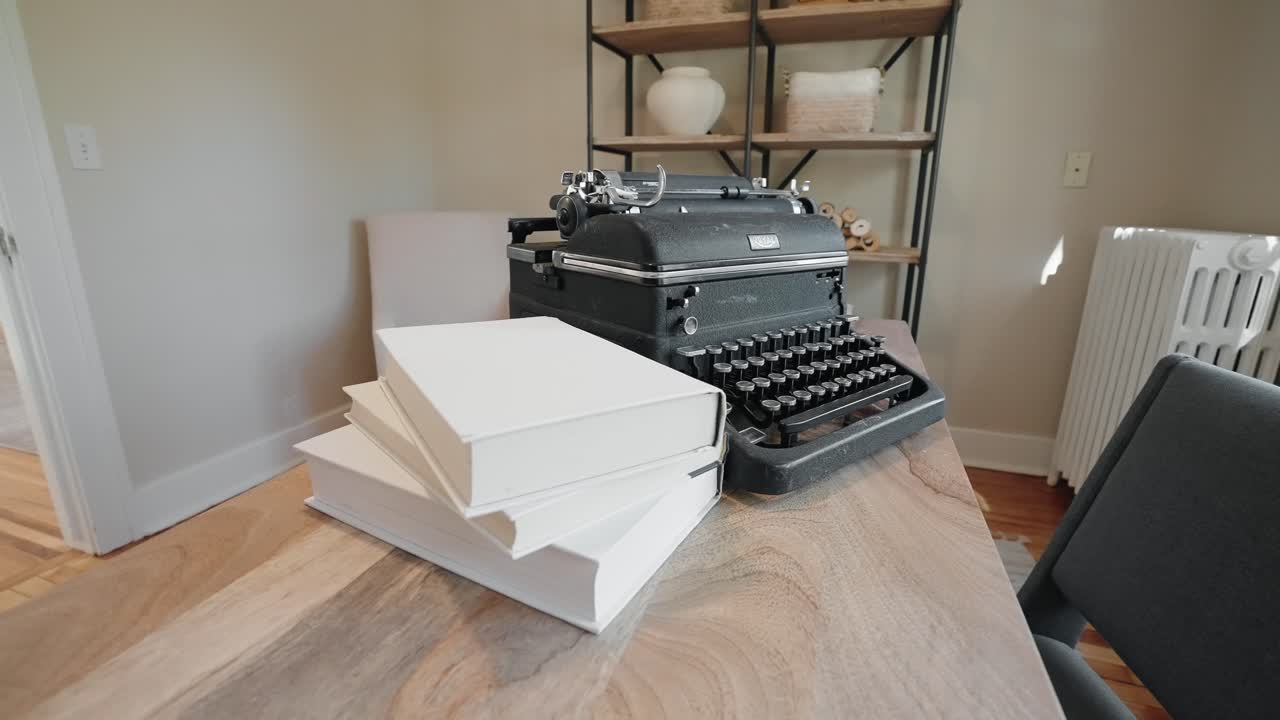 old typewriter and books on a wooden desk in the office of a home