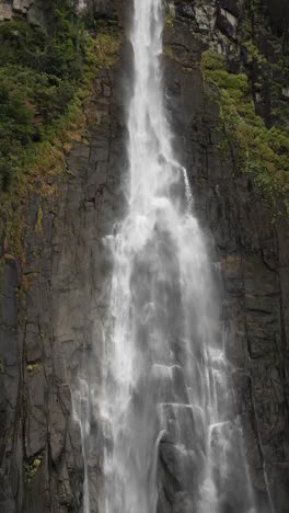 water gracefully flowing down nachi waterfall, creating a mesmerizing spectacle of nature's power in japan. slow motion, vertical video