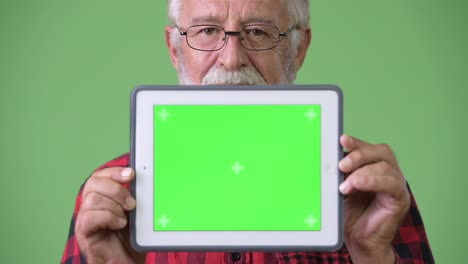 hombre de barba viejo y guapo contra un fondo verde.