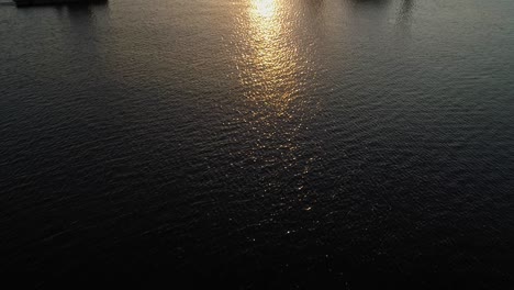 Tugboat-And-Hydraulic-Equipment-With-A-Golden-Sunset-And-Reflection-At-The-Baltic-Sea-In-Darlowko,-Poland