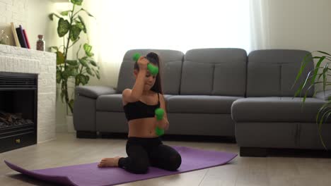 la niña está haciendo ejercicios de agachamiento en casa. el niño lindo está entrenando en una alfombra en el interior. la pequeña modelo femenina de cabello oscuro en ropa deportiva tiene ejercicios cerca de la ventana en su habitación