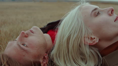 couple lying on field and smoking