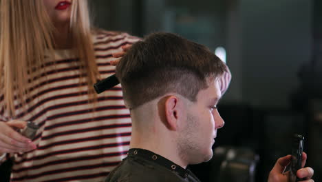 Vista-De-Cerca-Del-Peinado-Masculino-En-Una-Barbería-Con-Recortador-Profesional.-Corte-De-Pelo-Del-Hombre-En-Peluquería-Con-Cortapelos-Eléctrico.-Arreglar-El-Cabello.