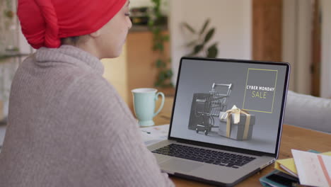 Biracial-woman-at-table-using-laptop,-shopping-online-on-cyber-monday,-slow-motion