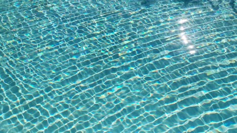 Water-surface-texture,-Slow-motion-looping-clean-swimming-pool-ripples-and-wave,-Refraction-of-sunlight-top-view-texture-sea-side-white-sand,-sun-shine-water-loop-background