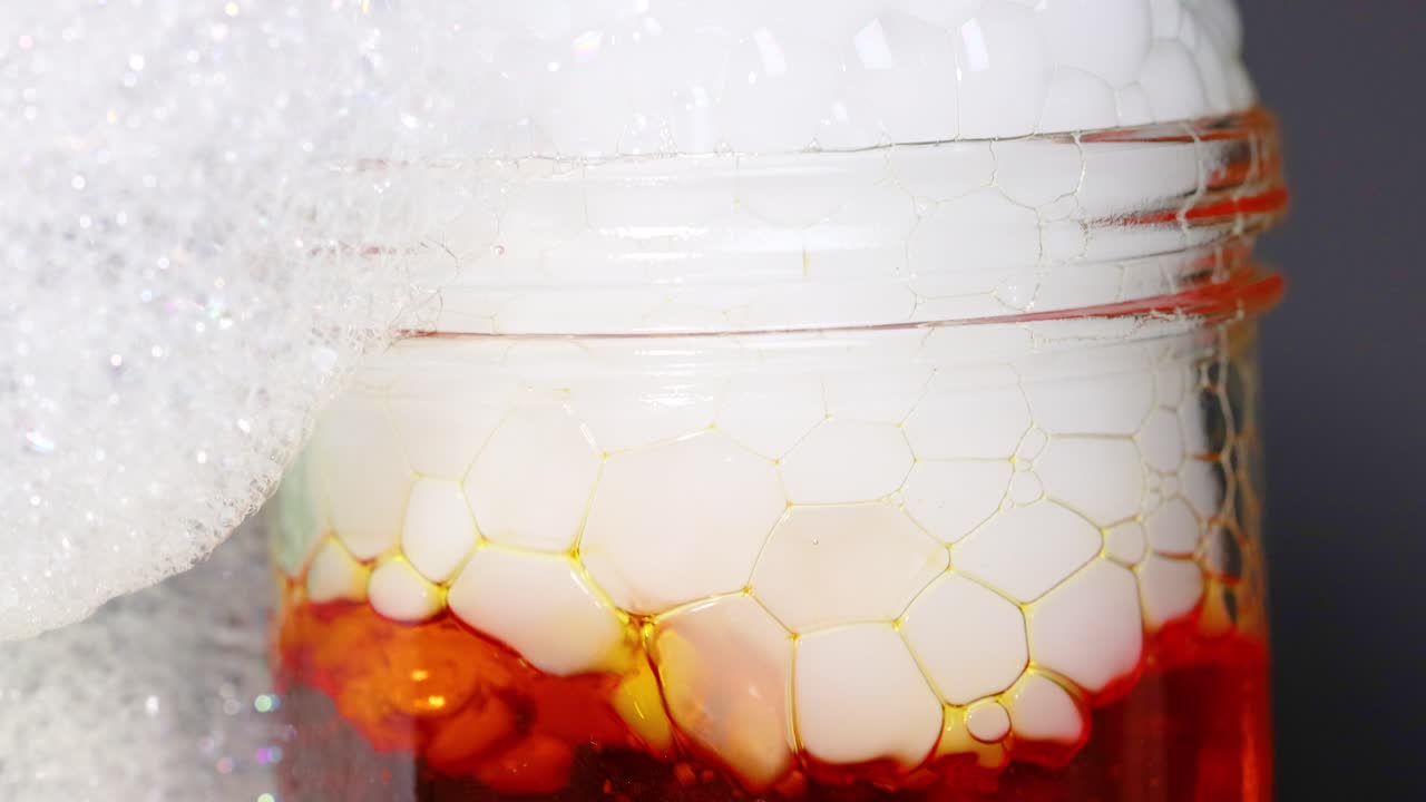 A vibrant science experiment showcasing dry ice creating bubbles in a liquid, producing a foamy overflow effect