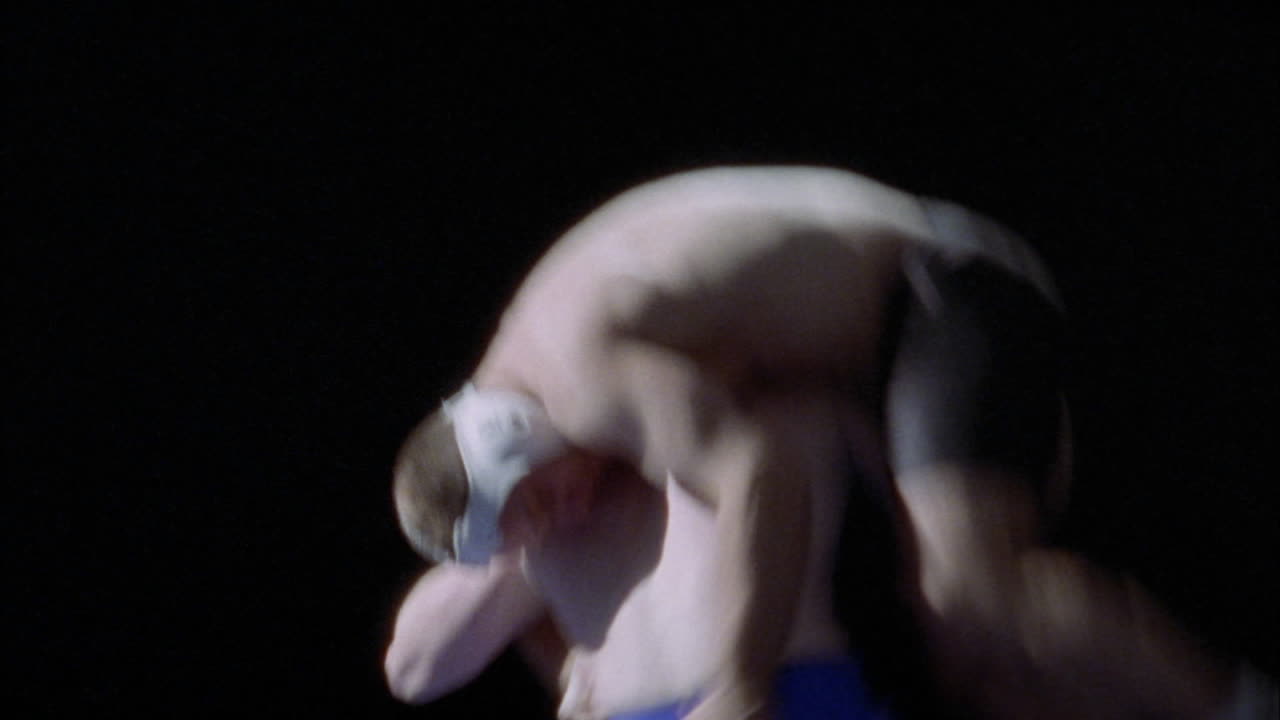 두 남자가 서로 경쟁적인 레슬링 경기에 참여하고 있습니다.