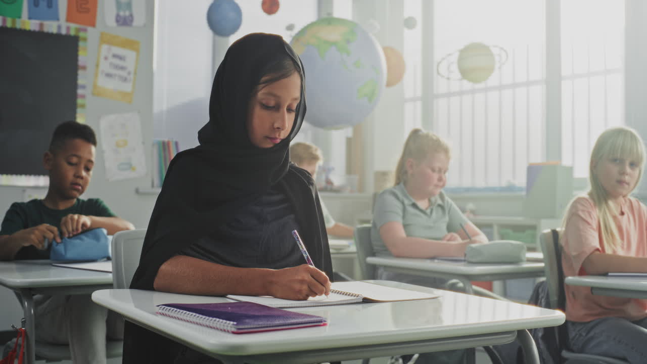 Portrait of Muslim Primary School Girl Wearing Hijab Looking at the Camera and Smiling